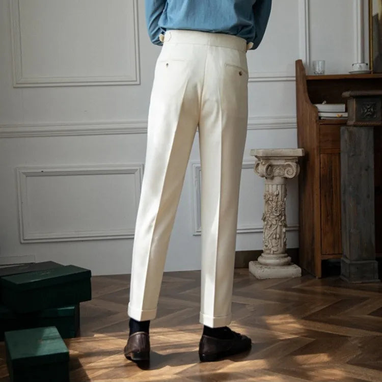 Person wearing white pants and a blue top in an indoor setting with wooden floor and decorative elements.